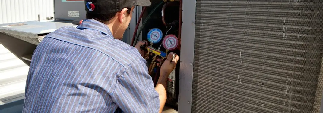 HVAC technician servicing a condenser unit in Eufaula